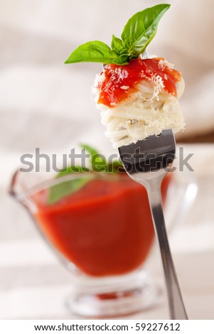 Spaghetti with sauce and parmesan cheese on a fork.