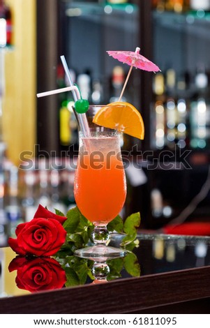Tequila sunrise cocktail and red rose