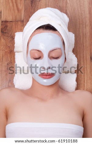 beautiful young woman with cosmetic mask on her face