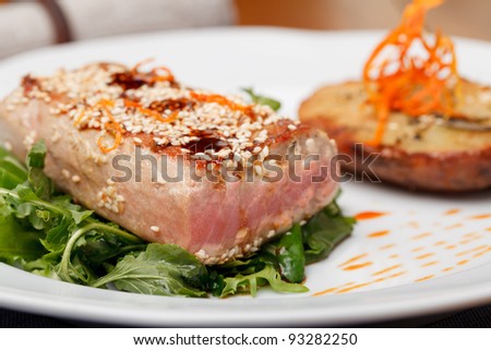 Fried tuna steak and potatoes on the plate