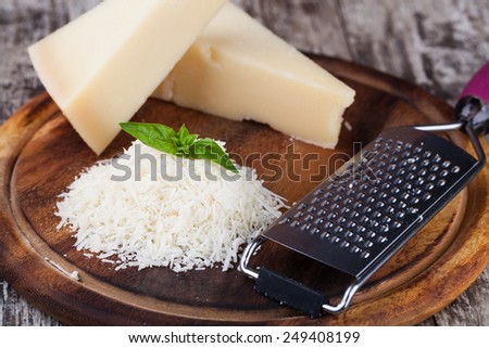 grated parmesan cheese and metal grater on wooden board
