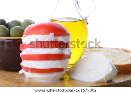 wooden cutting board with vegetables, oil, italian cheese  and bread