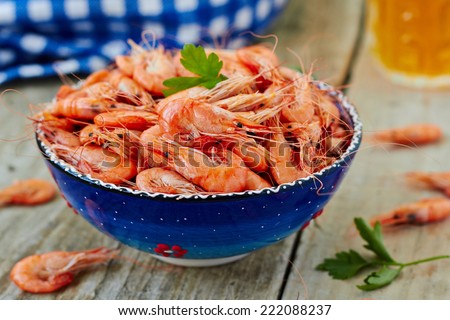 Prepared shrimp on blue plate on wooden background