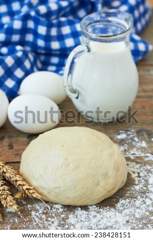 dough, milk and eggs on wooden table
