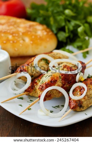 Minced meat  kebab on skewers with vegetables and flat bread
