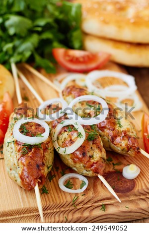 Minced meat kebab on skewers with vegetables and flat bread