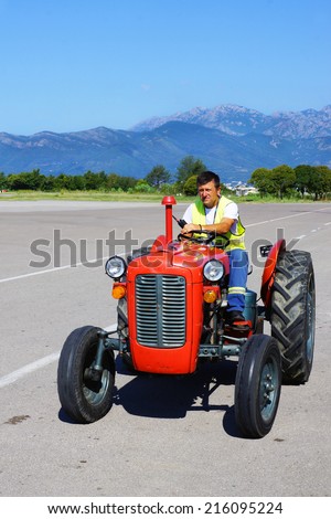 TIVAT, MONTENEGRO-28 AUGUSTUS. retro a mini tractor is used for transportation of baggage at the Tivat airport on August 28, 2014 . Tivat-one from two public airports of Montenegro