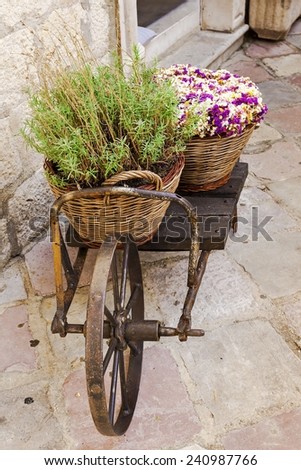 old wheelbarrow with baskets of flowers