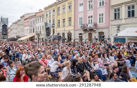 Lviv, Ukraine - June 2015: Alfa Jazz Fest 2015. Spectators sit in front of the stage jazz festival on the Market Square in Lviv near the town hall