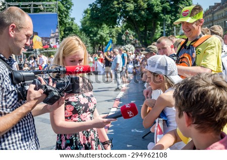 Lviv, Ukraine - July 2015: Yarych street Fest 2015. Correspondent channel 24 interviews a girl viewer competitions strongmen