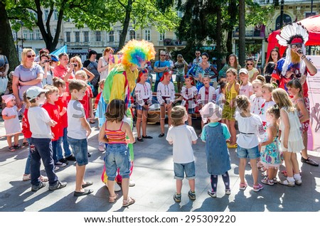Lviv, Ukraine - July 2015: Yarych street Fest 2015. Clown and Indian play, sing and dance with the children in the park