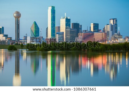 The classic Dallas, Texas skyline at dusk, with reflections in the Trinity River.