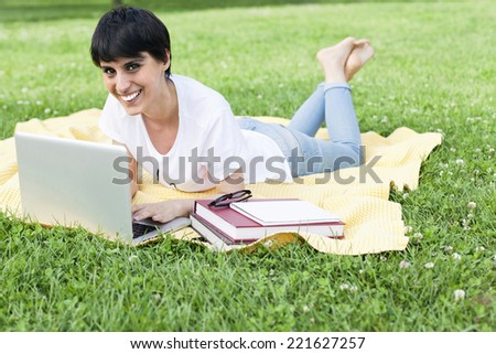 Young Girl Using Laptop on Green Grass / College student study in campus / University student preparing for exams / Happy University Student