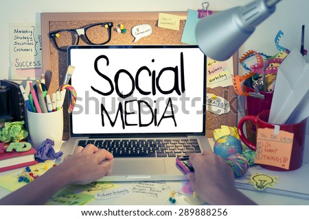 Social Media / Social media concept on laptop, hand typing on laptop keyboard in office interior