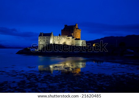 Eilean Donan Castle, Loch Duich, Scotland, at late evening showing lit castle against blue sky