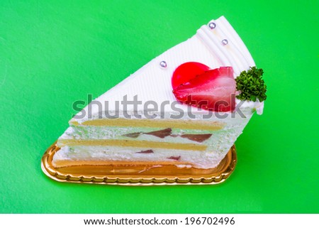 Strawberry cream cake in green background