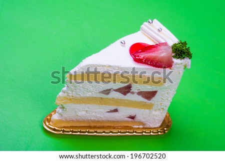 Strawberry cream cake in green background