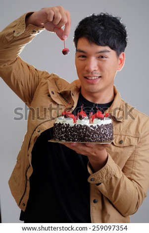 Asian man with birthday ice-cream cake on fire