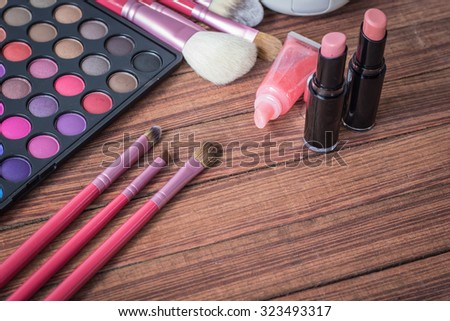 still life with various makeup products on wooden table