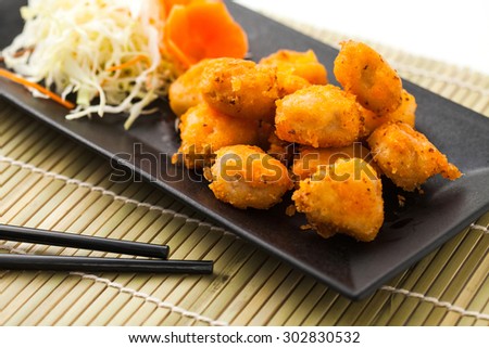 deep fry chicken joints on black plate on bamboo mat