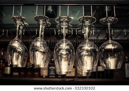 wine glasses in shelf above a bar rack in restaurant