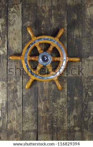 steering wheel of sailing-ship on a board background