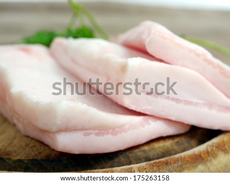 pork fat with parsley on board background