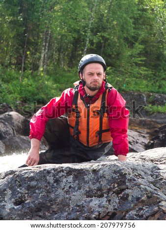 Portrait of a man in a helmet and life jacket on forest background