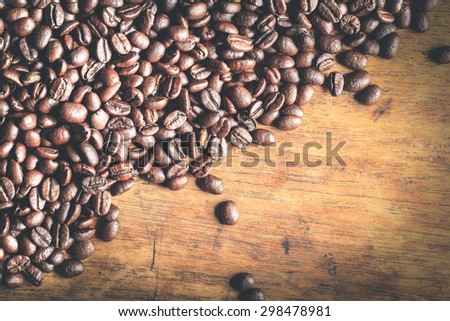 A coffee mug of coffee beans on wood - fade effect