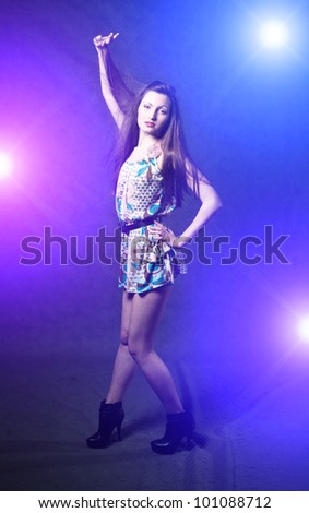 Sexy young self-confident brunette girl dancing in discolight