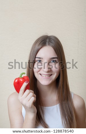 beautiful girl pretty smile with red sweet pepper head and shoulders shot - organic food and health concept