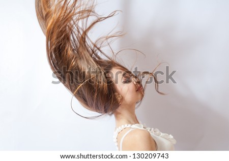 Pretty 20-24 years old blonde girl with great fly-away hair on white background