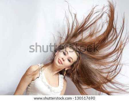Pretty 20-24 years old blonde girl with great fly-away hair on white background