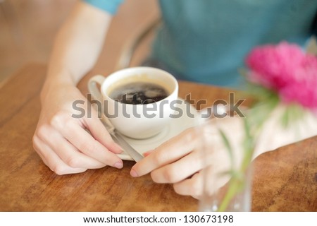 Closeup of female hands holding a mug. Selective focus on hands and fingers.