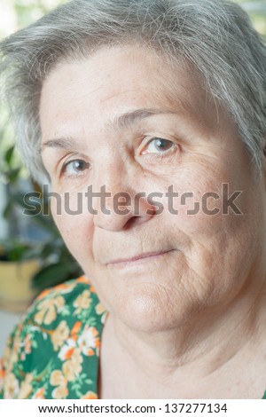 Blank expression closeup face senior woman. Indoors