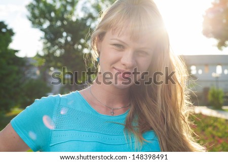 Beautiful pregnant woman in sunny park. Beautiful blond early 30s woman head shot portrait outdoors sweeping hair back