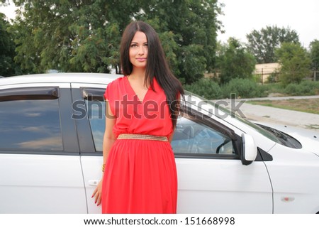 Sexy Beauty Woman In Fluttering Red Dress Standing near car