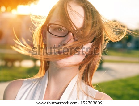 portrait of a beautiful red ginger haired 20s girl with freckles, close-up shot, hair by the wind, freedom concept or summer fun