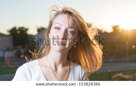 sunset shot of 20s blonde backlit head and shoulders