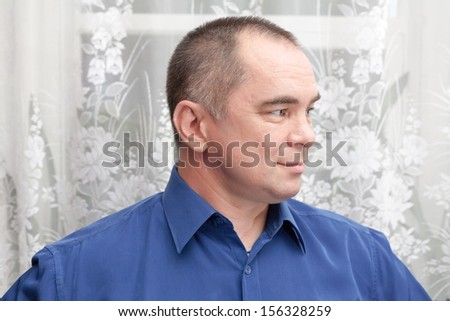 casual weared mid age man indoors, looking away , looking away