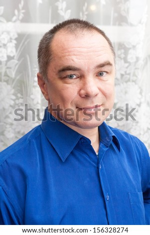 casual weared mid age man indoors, looking at camera