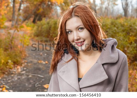 foxy-red haired women outdoors weared jacket at autumn time. Smiling and enjoy autumn air