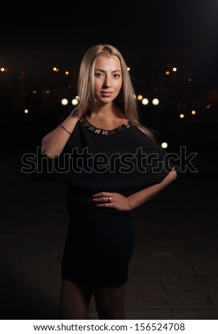 Beautiful blond woman walking alone outdoors at night