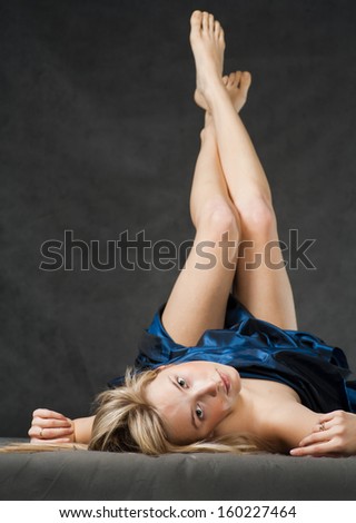 Beautiful model dressed in fabrick laying on floor with legs up in air