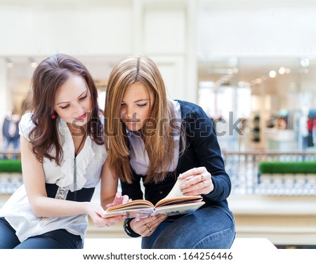 Collaboration concept. Two women reading interesting book