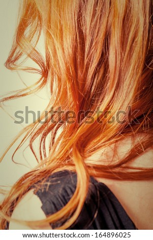 Close up natural carrot color curly hair from back