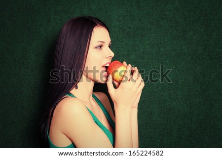 women smiling and bite an apple