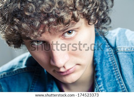 Very closeup portrait of a young caucasian guy with curly hair