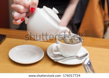 side view of a female pouring tea