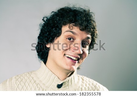 Curly white man in studio smiling